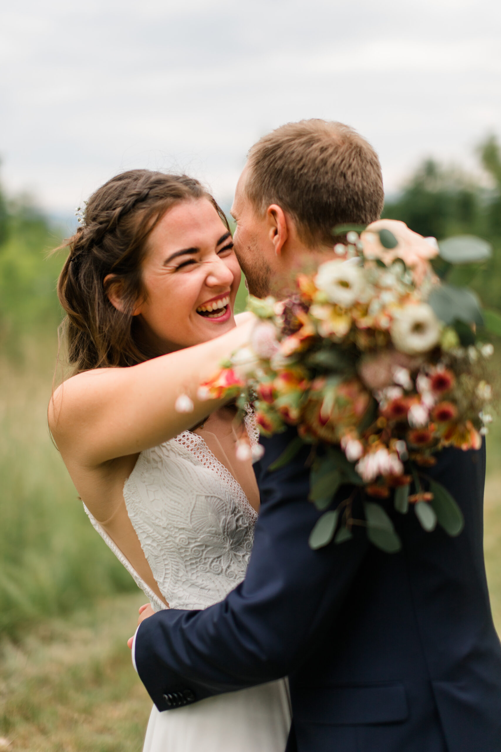 Lachende Braut umarmt Bräutigam